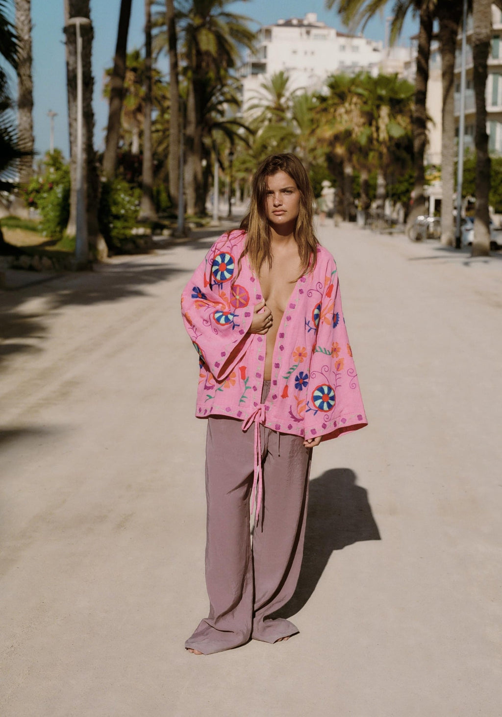 Femme portant le kimono court rose ouvert sur un pantalon large