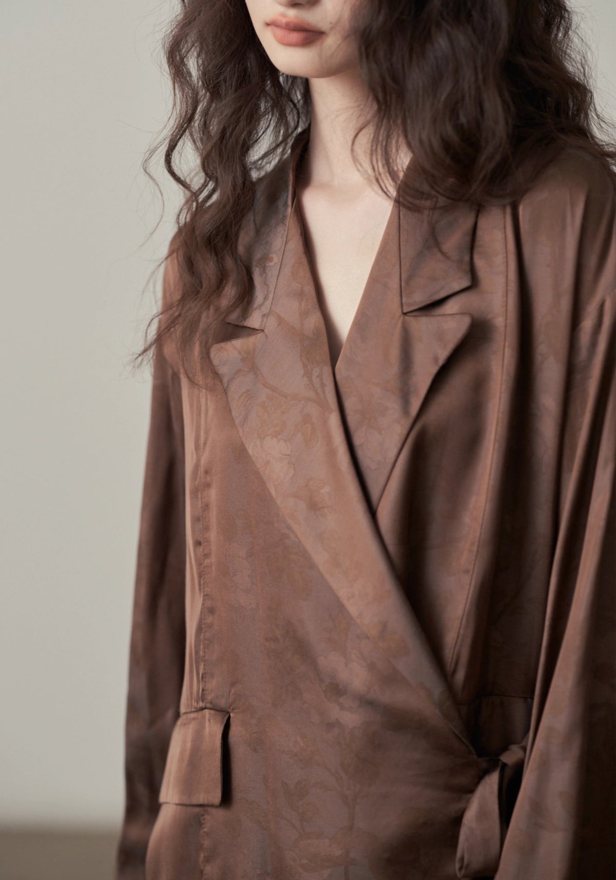 Détail du motif jacquard ton sur ton du tissu satiné marron