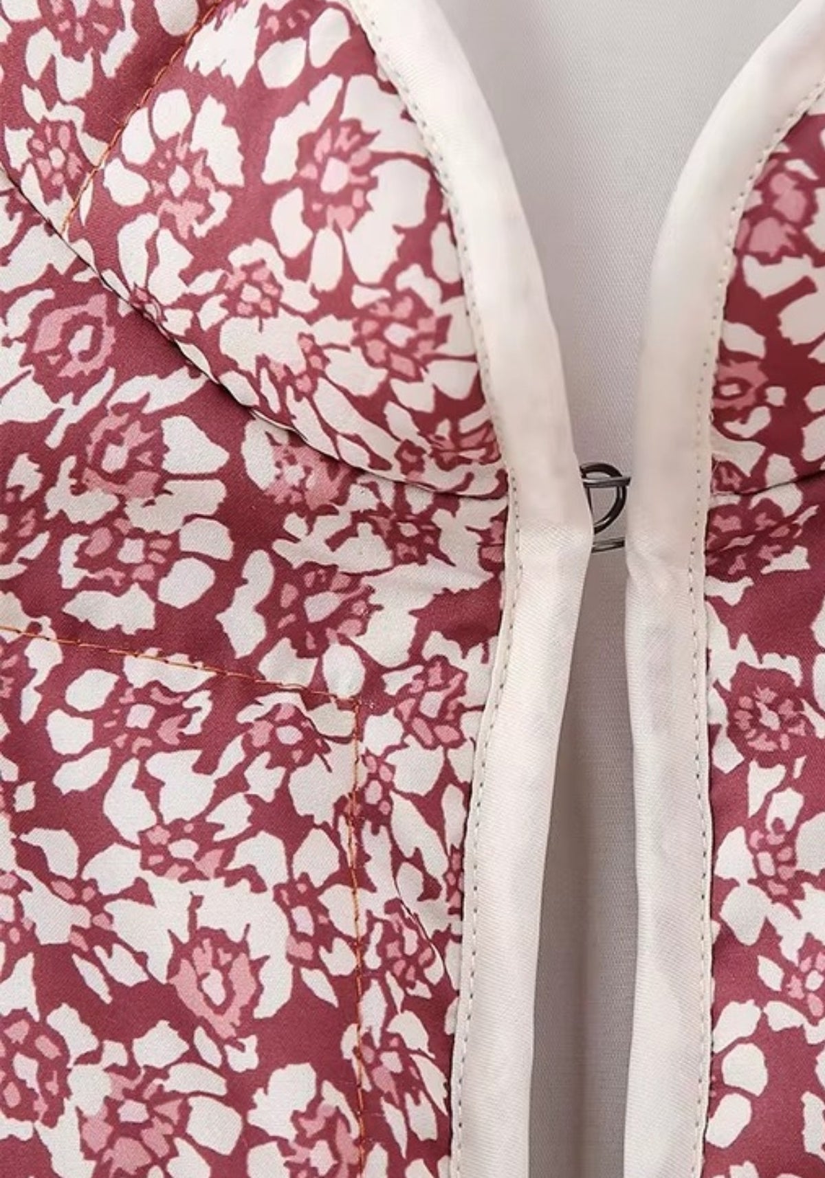 Détail du passepoil crème sur le motif floral prune