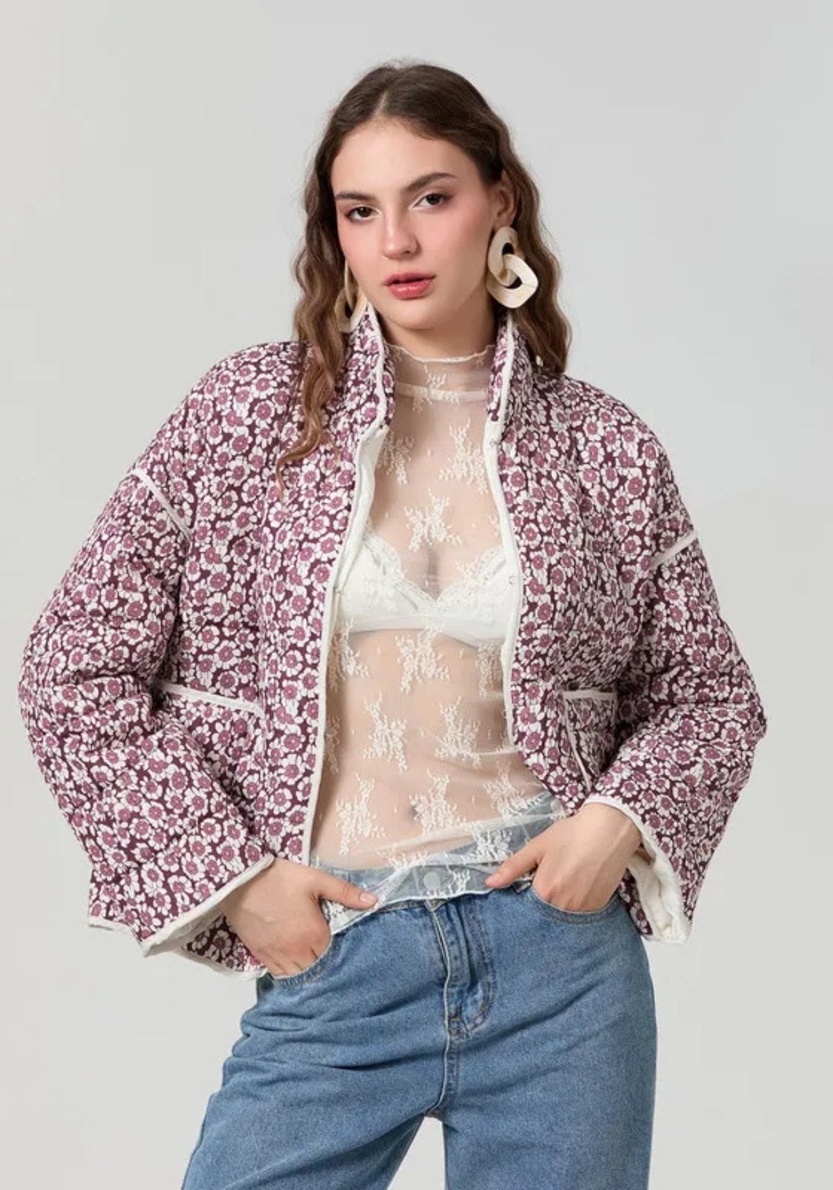 Femme portant la veste matelassée fleurie prune ouverte sur un jean