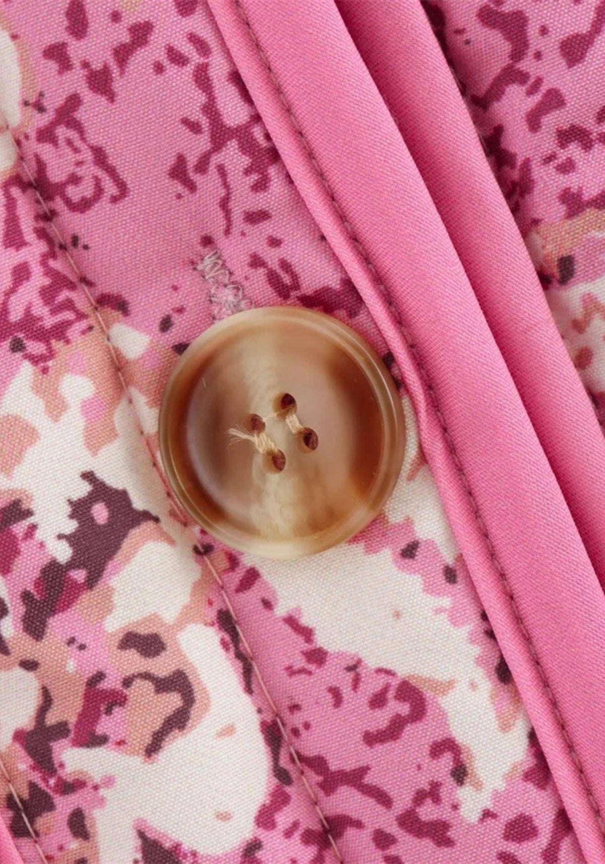 Détail d'un bouton et de la patte de boutonnage rose unie